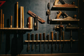 Woodworking tools neatly arranged on a dark wall